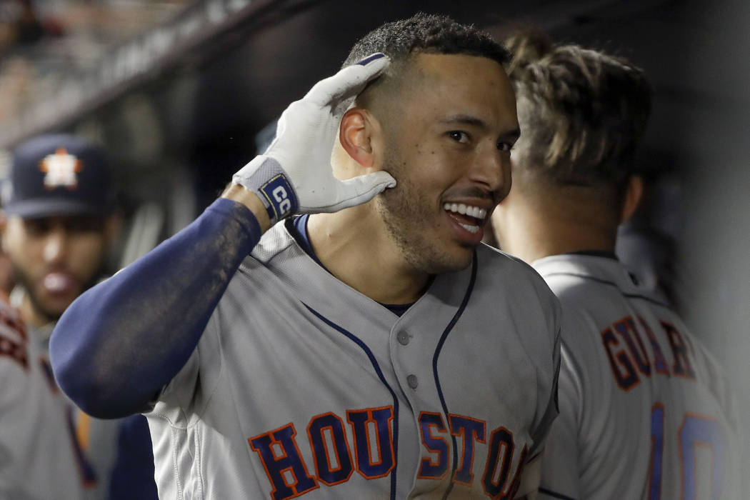 Houston Astros' Carlos Correa reacts in the dugout after hitting a three-run home run against t ...