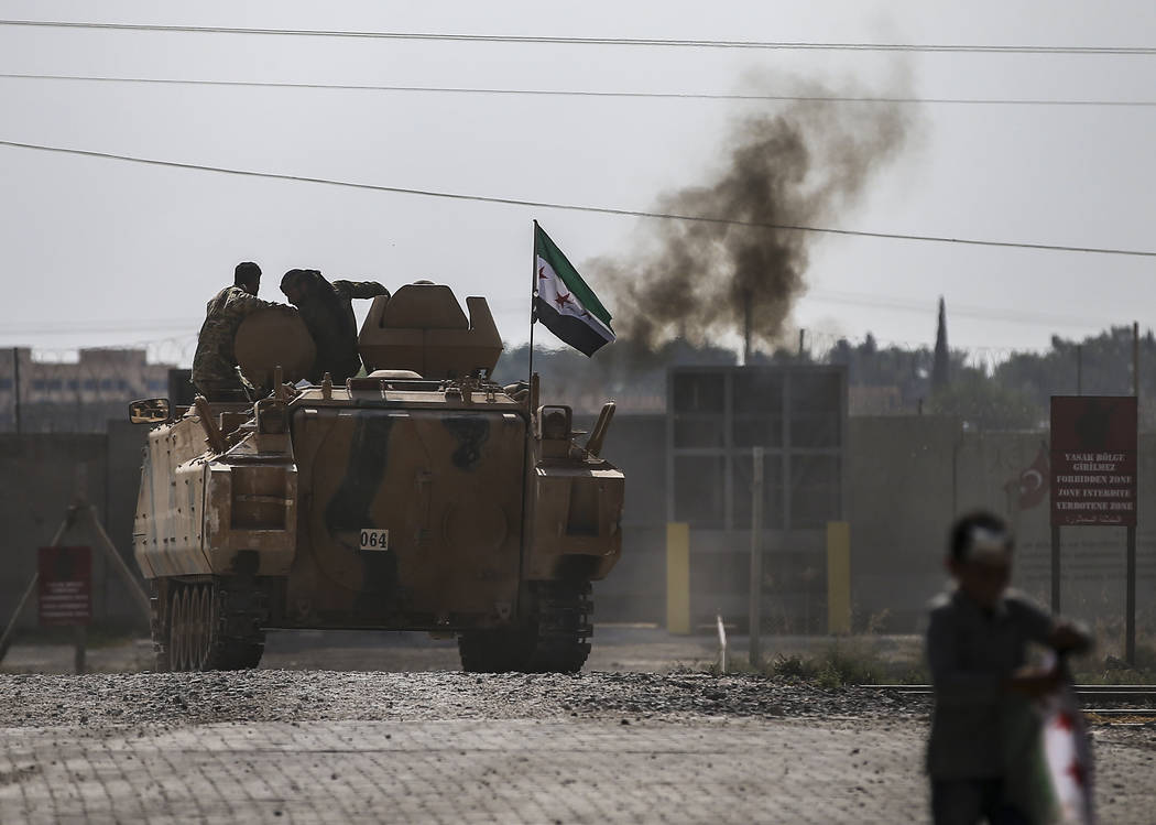 Turkish-backed Syrian opposition fighters on an armoured personnel carrier drive to cross the b ...