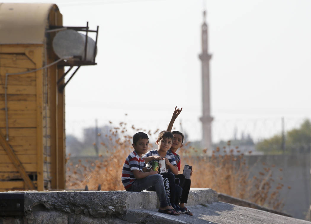 Children gesture to the camera in Akcakale Sanliurfa province, southeastern Turkey, at the bord ...