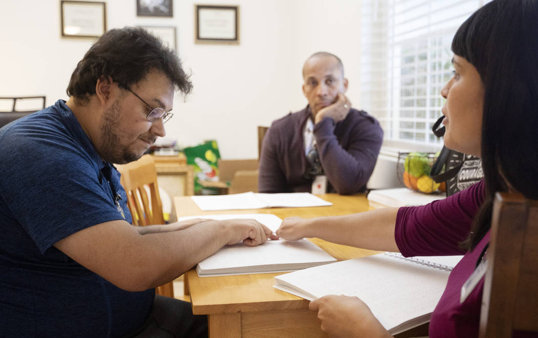 BlindConnect President Raquel O'Neill, right, goes through a Braille lesson with Ivan Medina, l ...