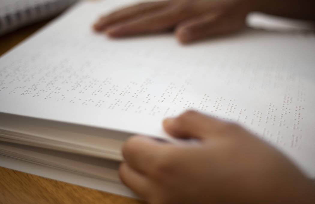 BlindConnect President Raquel O'Neill pages through a Braille lesson on Friday, Oct. 18, 2019 a ...