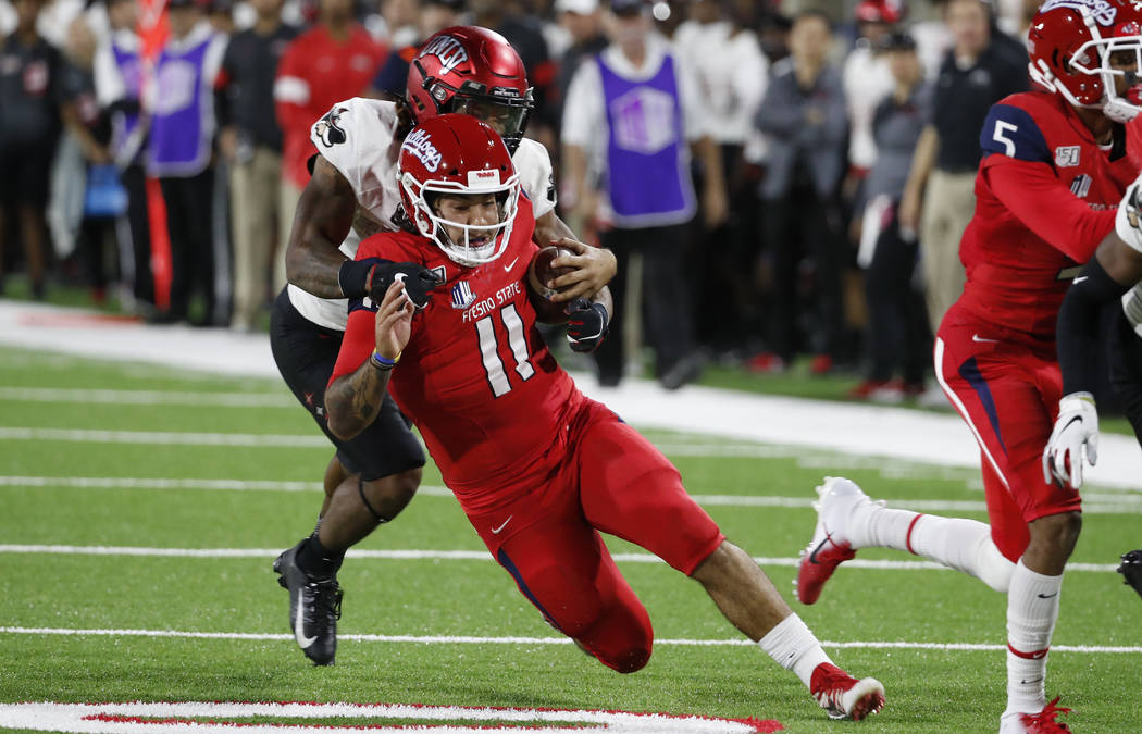 UNLV defensive back Evan Austrie tackles Fresno State quarterback Jorge Reyna during the first ...