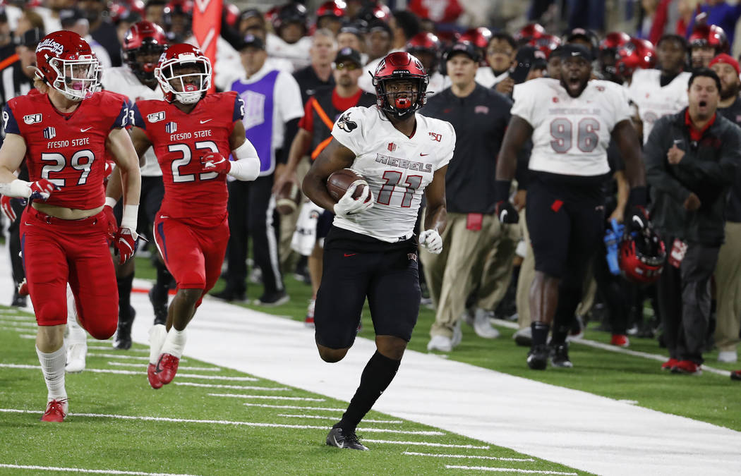 UNLV tight end Noah Bean for a long gain as Fresno State linebacker Justin Rice, left, and defe ...