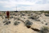 In this July 7, 2019 file photo, a visitor takes a photo of a crack in the ground following rec ...