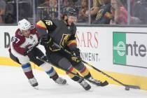 Golden Knights defenseman Jake Bischoff (45) fights for possession with Colorado Avalanche left ...