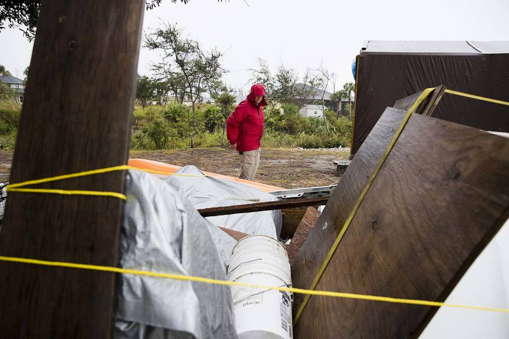Chris Anderson ties down building materials and other objects from his lawn as Tropical Storm N ...