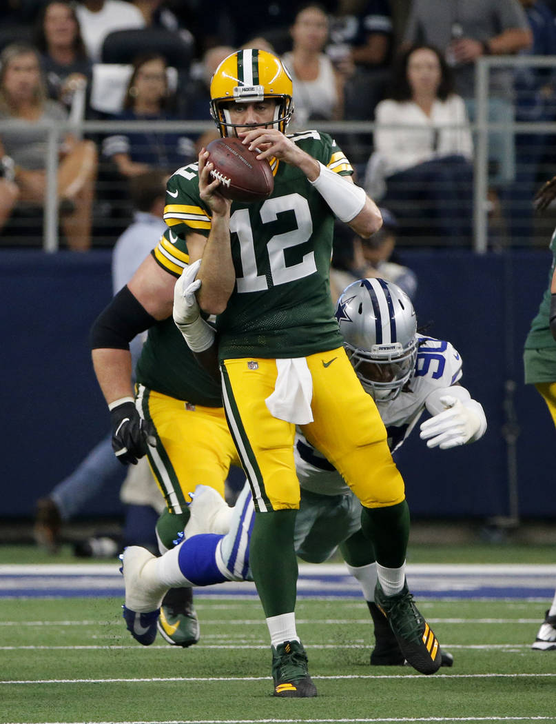 Green Bay Packers' Aaron Rodgers (12) throws an incomplete pass under pressure from Dallas Cowb ...