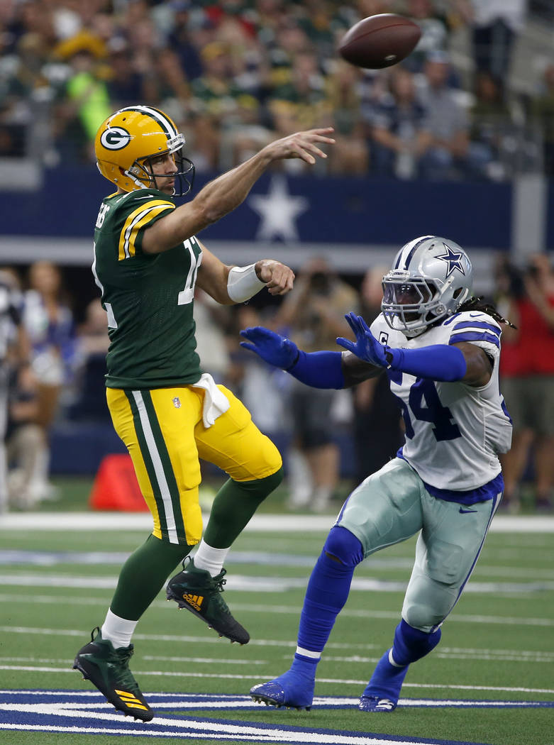 Green Bay Packers quarterback Aaron Rodgers (12) throws a pass as the Dallas Cowboys' Jaylon Sm ...