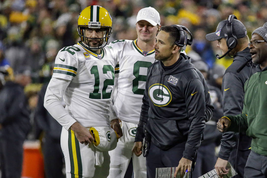 Green Bay Packers quarterback Aaron Rodgers (12) and head coach Matt LaFleur, third from left, ...