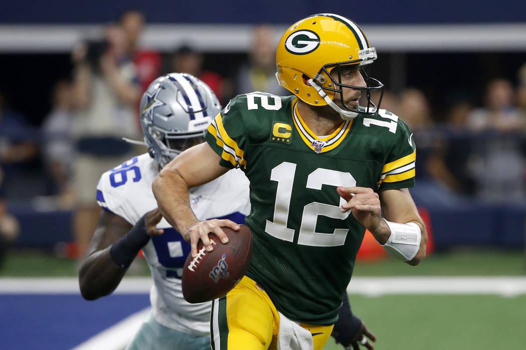 Green Bay Packers quarterback Aaron Rodgers (12) scrambles out of the pocket as Dallas Cowboys ...