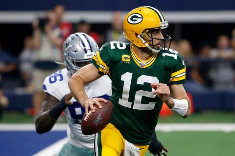 Green Bay Packers quarterback Aaron Rodgers (12) scrambles out of the pocket as Dallas Cowboys ...