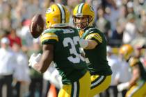 Green Bay Packers quarterback Aaron Rodgers (12) flicks the football to running back Aaron Jone ...