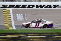 Denny Hamlin (11) crosses the finish line to win a NASCAR Cup Series auto race at Kansas Speedw ...