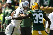 Oakland Raiders wide receiver Keelan Doss (18) stiff arms Green Bay Packers defensive back Chan ...