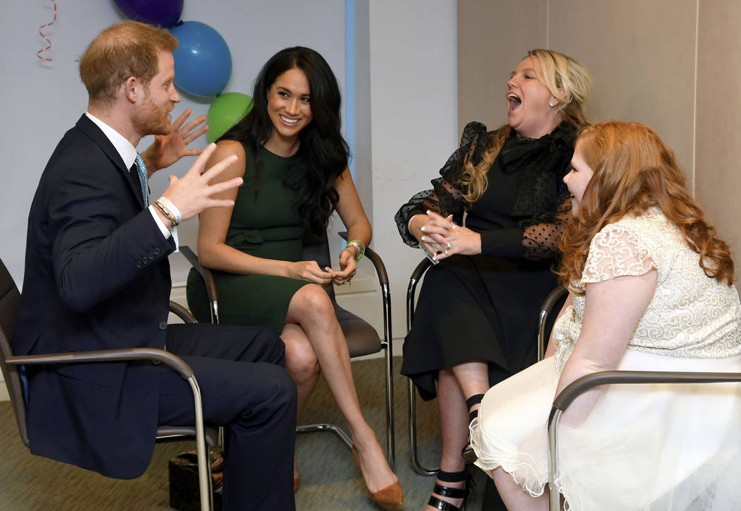 Britain's Prince Harry and Duchess of Sussex, left, meet with Milly Sutherland, right, and her ...