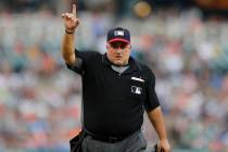 Home plate umpire Eric Cooper signals during the third inning of a baseball game between the De ...