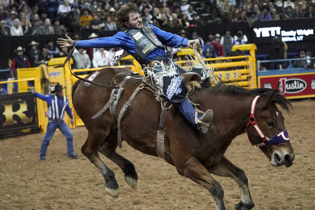 Rusty Wright of Milford, Utah (20) competes in the saddle bronc riding event during the eighth ...