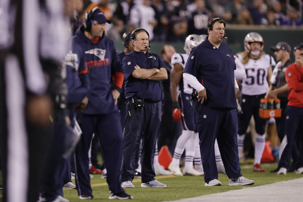 New England Patriots head coach Bill Belichick, center left, watches his team play during the f ...