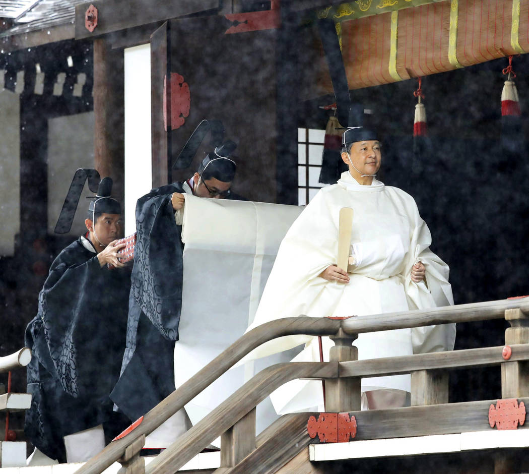 Japan's Emperor Naruhito, in a white robe, leaves after praying at “Kashikodokoro&#x201d ...
