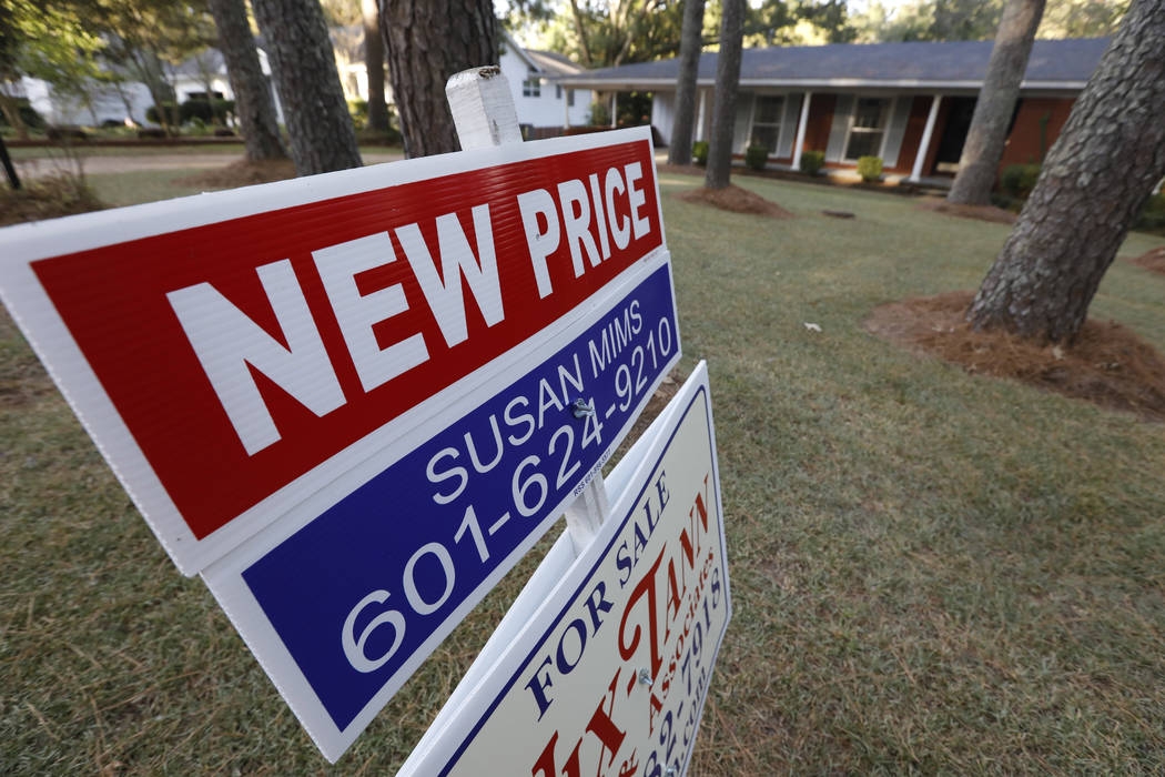 A Sept. 25, 2019, photo shows a sign indicating a new selling price for a house sits atop a Rea ...