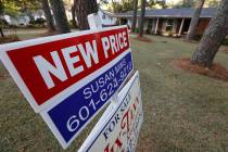 A Sept. 25, 2019, photo shows a sign indicating a new selling price for a house sits atop a Rea ...