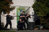 Santa Rosa police officers hold guns as they search the campus of Ridgway High School for suspe ...
