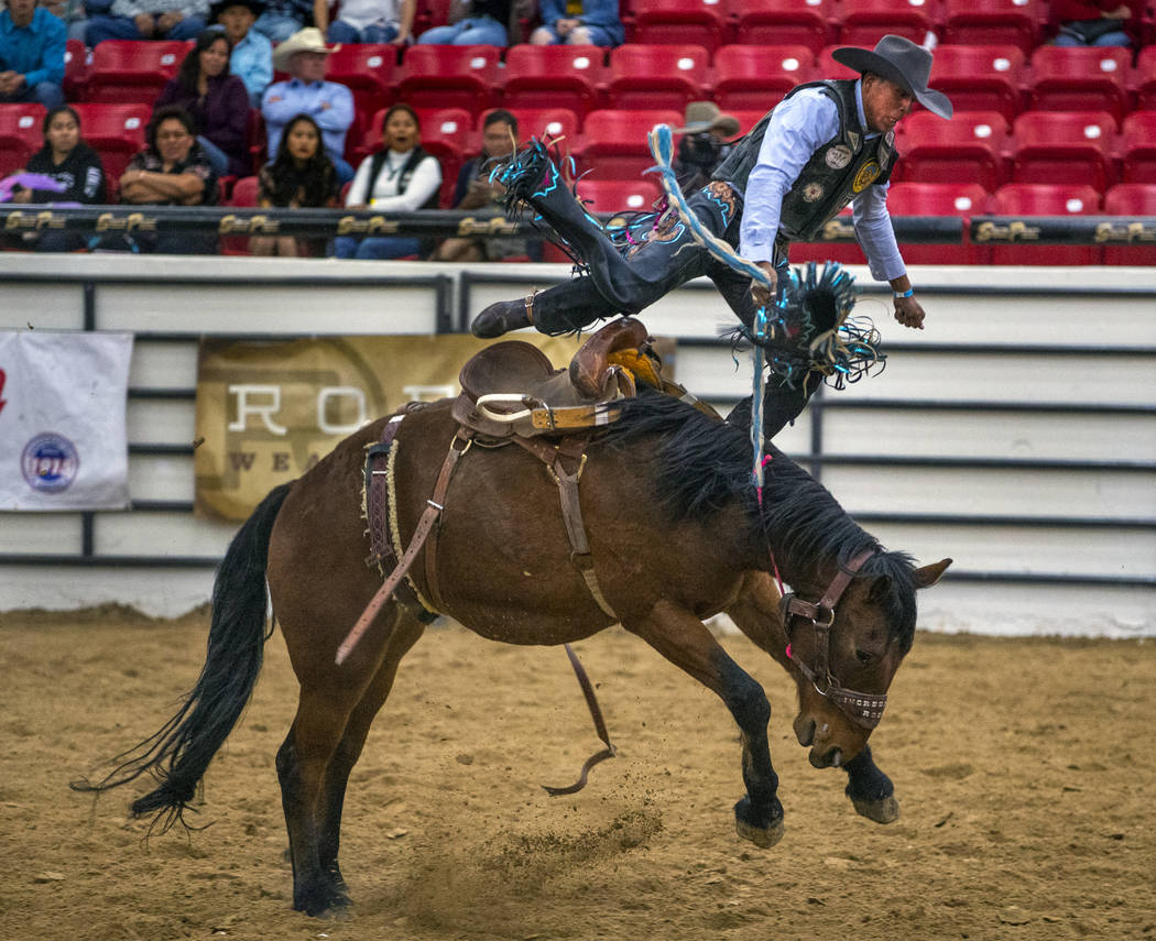 Saddle bronc rider Jay Joaquin gets thrown up into the air above the horse during the first rou ...