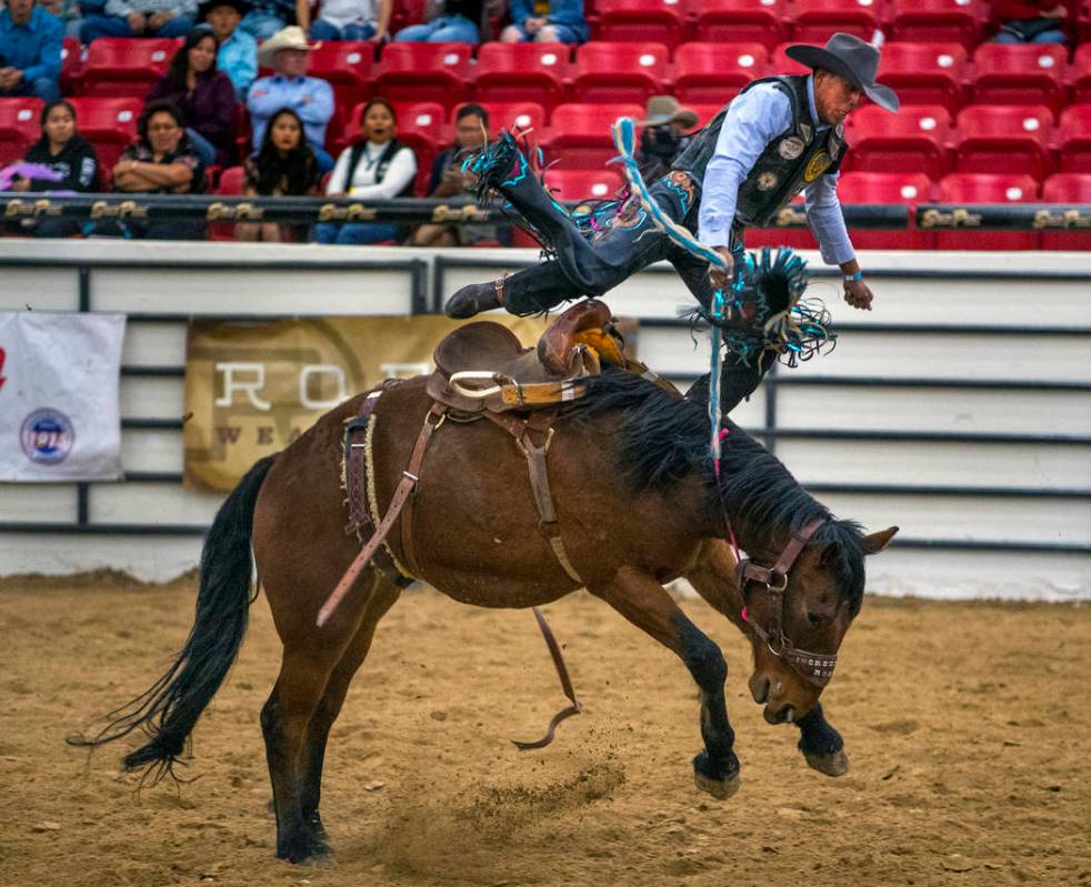 Saddle bronc rider Jay Joaquin gets thrown up into the air above the horse during the first rou ...