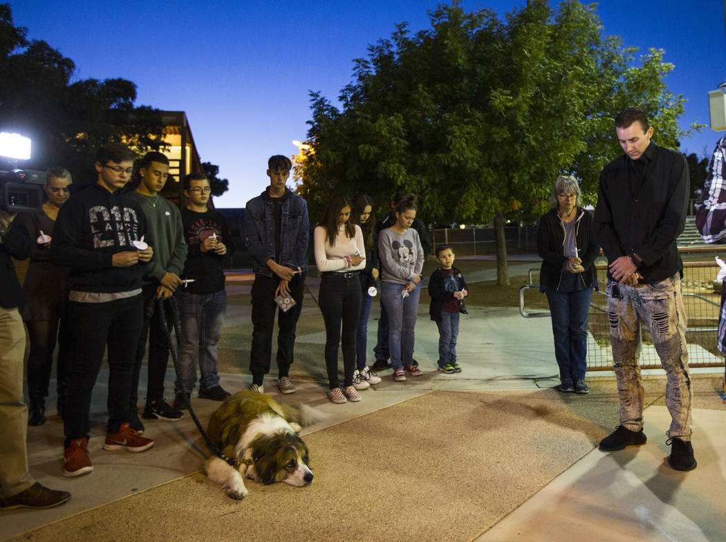 Sean Murray, far right, prays alongside family and friends during a candlelight vigil for his s ...