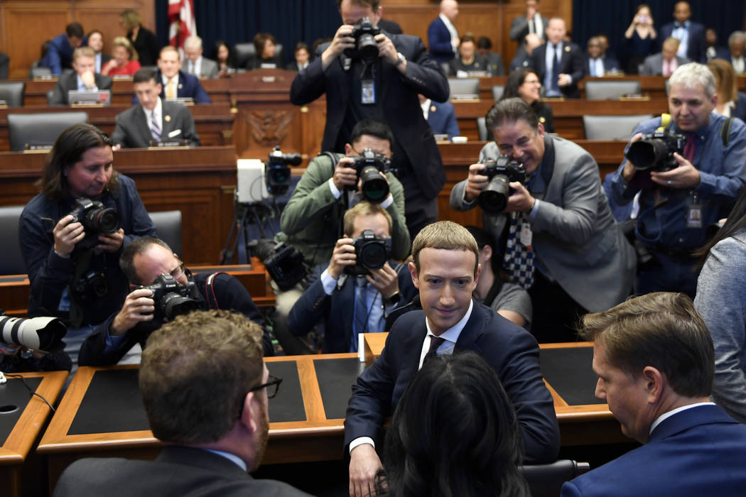 Facebook Chief Executive Officer Mark Zuckerberg, center, is surrounded by photographers after ...