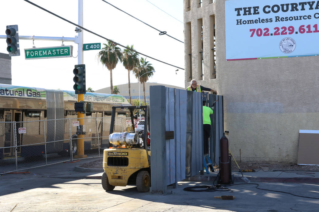 Workers install a gate at the corner of Las Vegas Boulevard and Foremaster Lane near the Courty ...