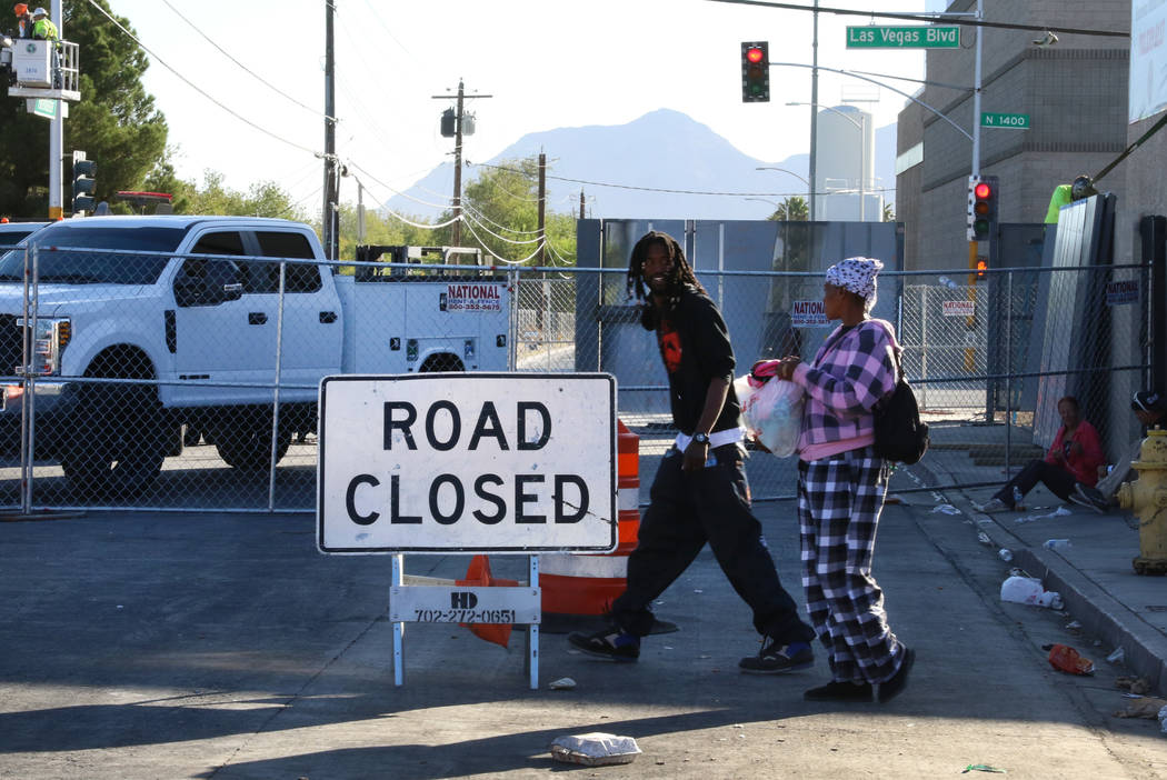 Clients walks past road closure sign outside the Courtyard Homeless Resource Center on Wednesda ...