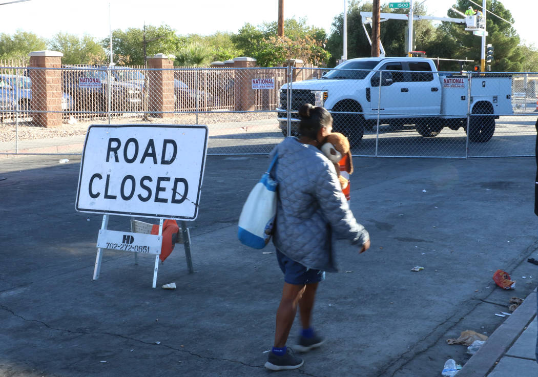 A client walks past road closure sign outside the Courtyard Homeless Resource Center on Wednesd ...