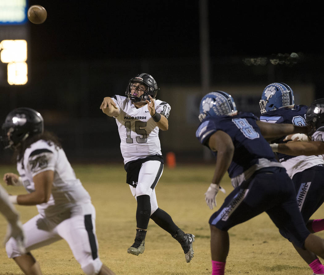 Palo Verde senior quarterback Paul Myro (15) makes a running throw over Centennial senior Thoma ...