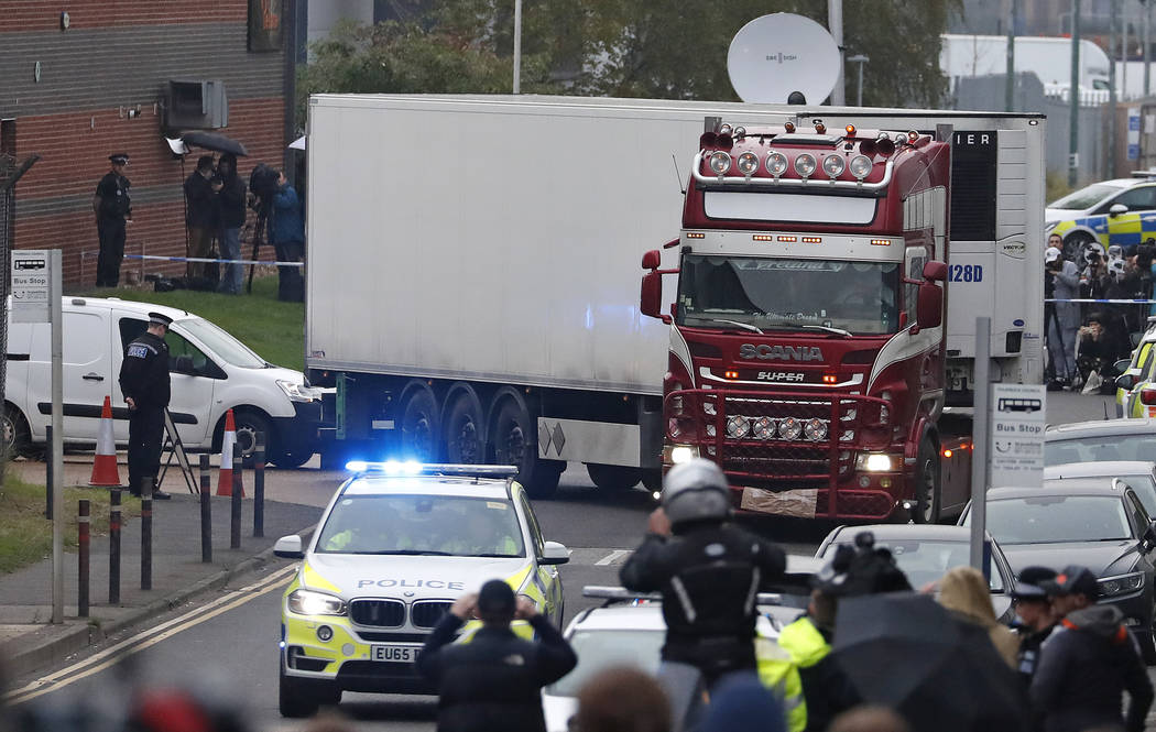 Police escort the truck, that was found to contain a large number of dead bodies, as they move ...