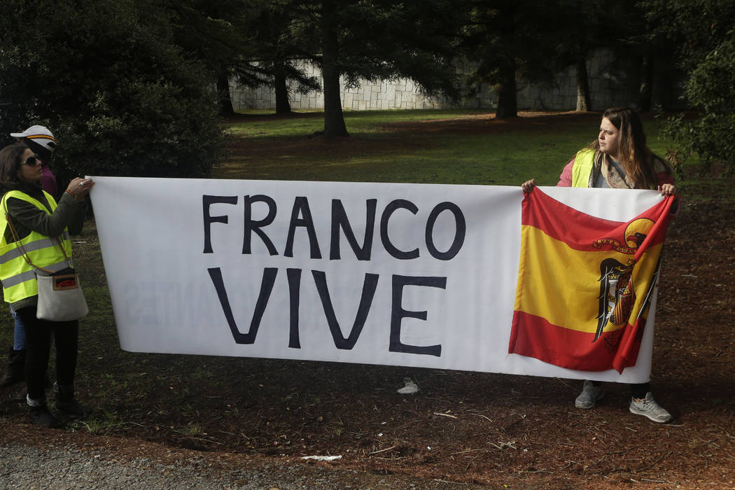 People carrying a banner reading in Spanish "Franco is alive" and holding a pre-const ...