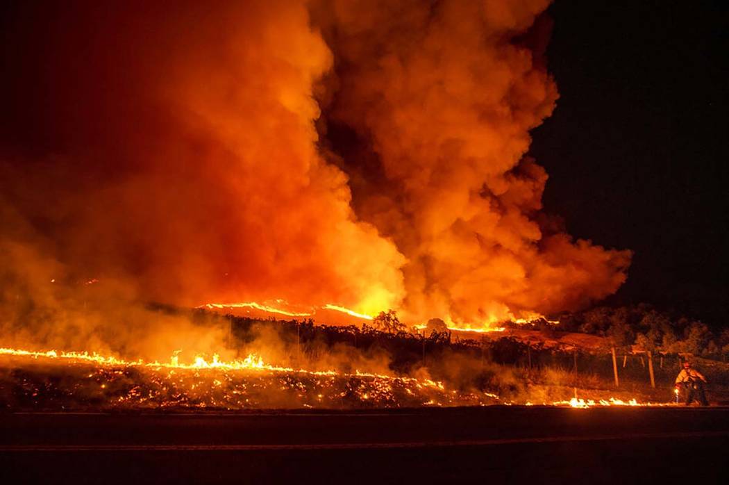 A firefighter battles the Kincade Fire near Geyserville, Calif., on Thursday, Oct. 24, 2019. Po ...