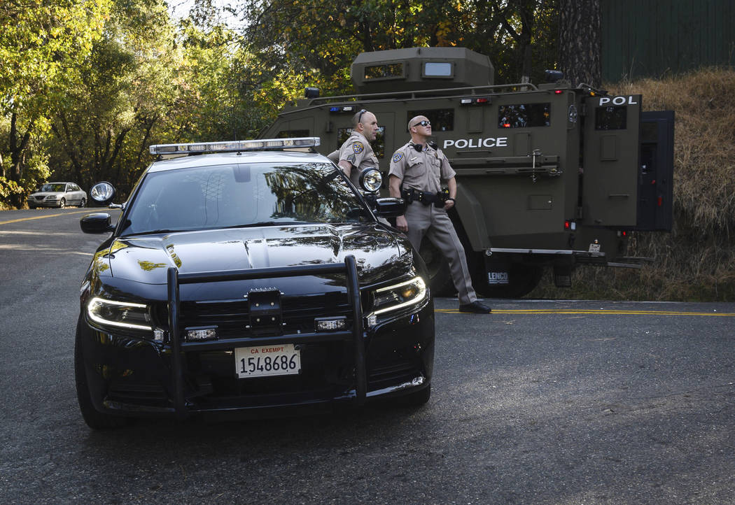 California Highway Patrol officers block off a road where El Dorado County sheriff...