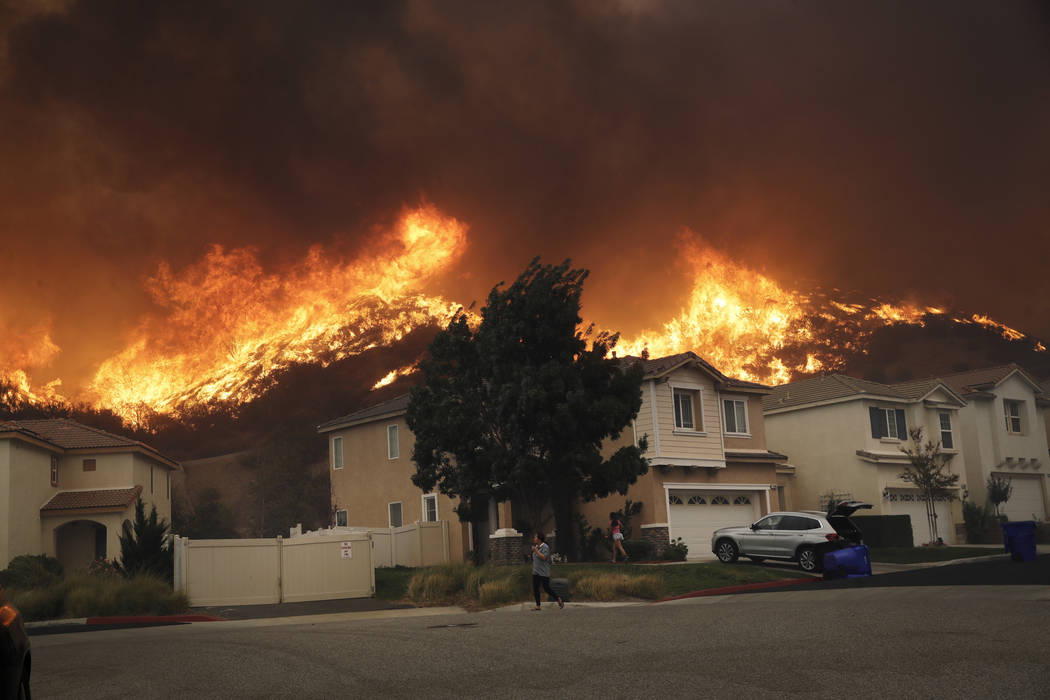 A wildfire approaches a residential subdivision Thursday, Oct. 24, 2019, in Santa Clarita, Cali ...