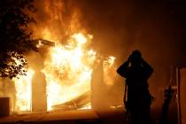 A firefighter prepares to fight a wildfire as it overtakes a home Thursday, Oct. 24, 2019, in S ...