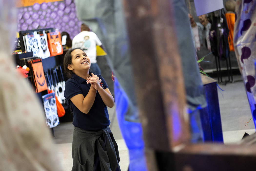 Luna Martinez, 9, of Las Vegas, giggles as an interactive Halloween display jumps out at her at ...