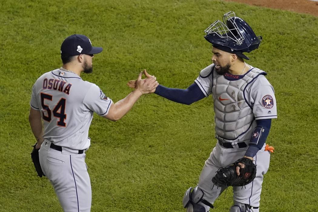Houston Astros' Roberto Osuna and Robinson Chirinos celebrate after Game 3 of the baseball Worl ...