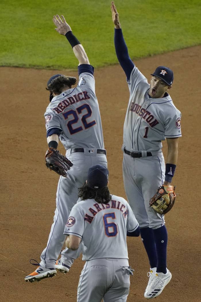 Houston Astros' Carlos Correa and Josh Reddick celebrate after Game 3 of the baseball World Ser ...