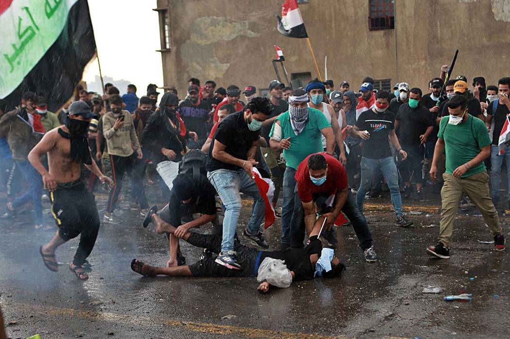 An injured protestor is rushed to a hospital during a demonstration in central Baghdad, Iraq, F ...