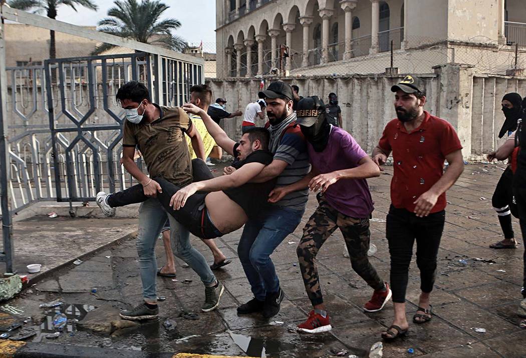 An injured protestor is rushed to a hospital during a demonstration in central Baghdad, Iraq, F ...