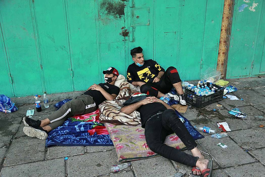 Anti-government protesters rest during sit-in at Tahrir Square in Baghdad, Iraq, Saturday, Oct. ...