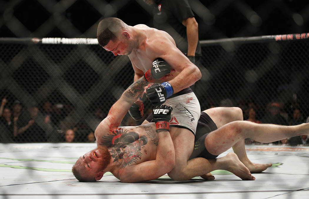 FILE - In this March 5, 2016, file photo, Nate Diaz, top, trades punches Conor McGregor during ...