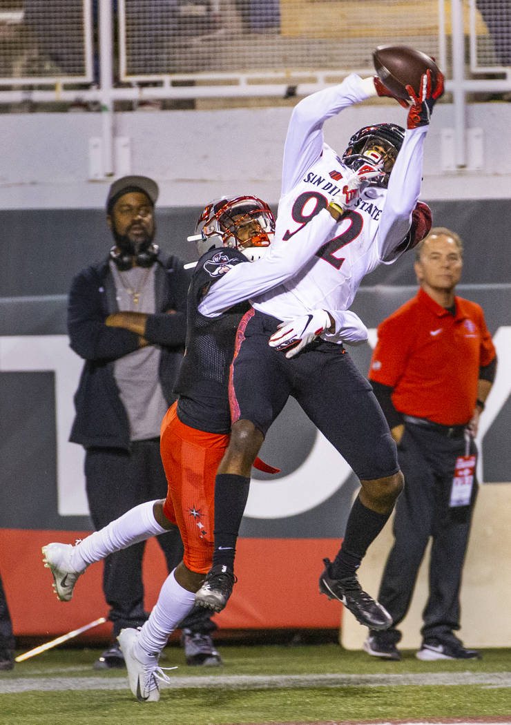 UNLV Rebels defensive back Myles Plummer (14) breaks up a pass to San Diego State Aztecs wide r ...
