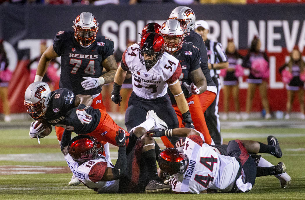 UNLV Rebels running back Charles Williams (8) dives over San Diego State Aztecs safety Trenton ...