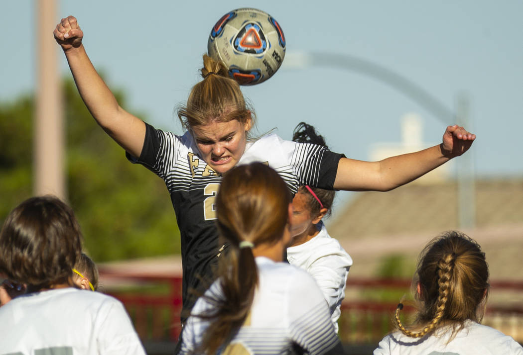 Faith Lutheran's Amelia McManus (20) heads the ball away from Arbor View defenders during the f ...